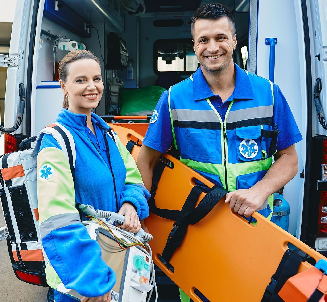 Ambulanciers prenant la pose devant leur véhicule avec du matériel de secours