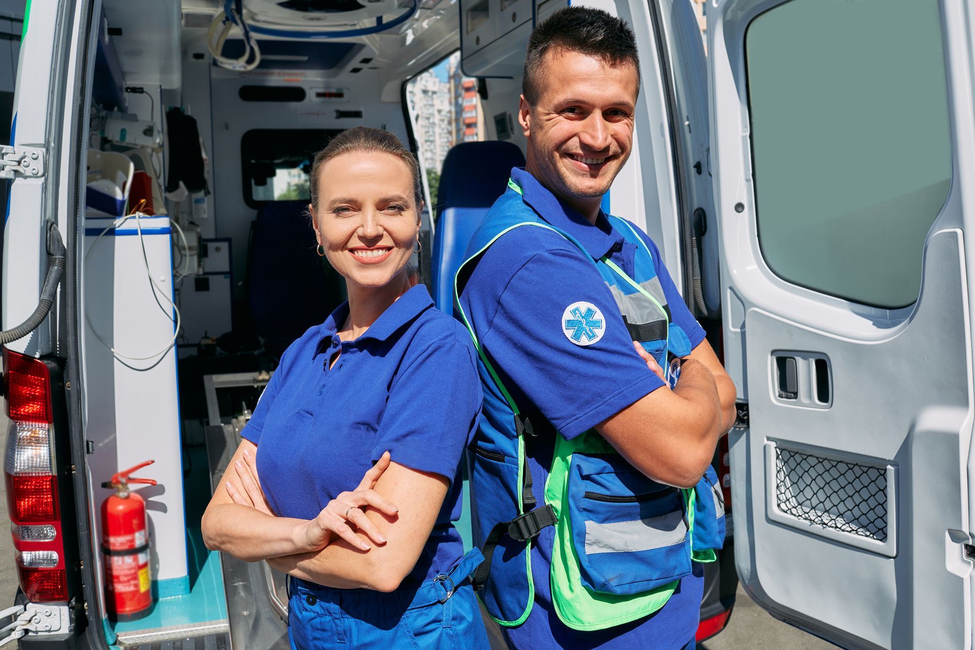 Ambulanciers prenant la pose dos à dos, souriants