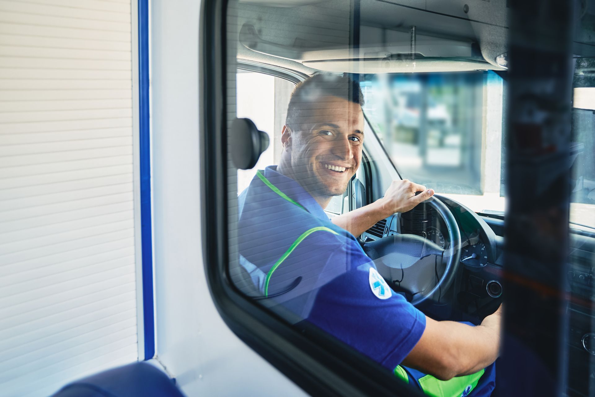 Ambulancier souriant assis dans son véhicule