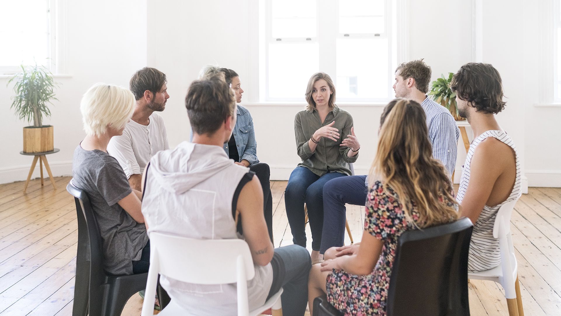 Un grupo de personas está sentado en círculo en una habitación.