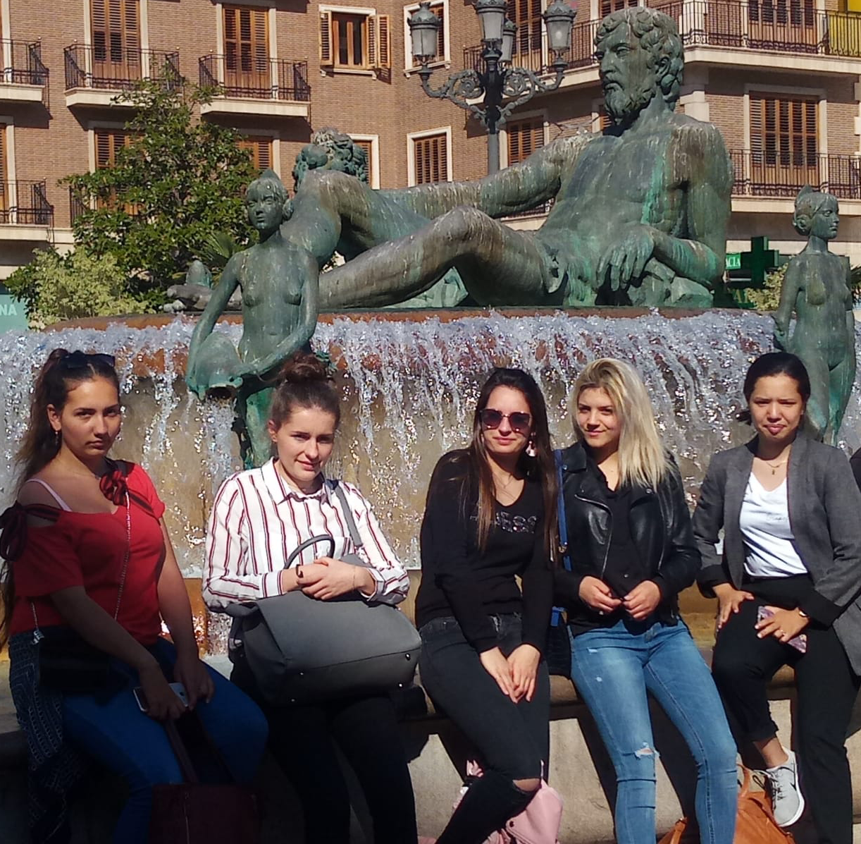 Des élèves posent devant une fontaine ornée d’une statue