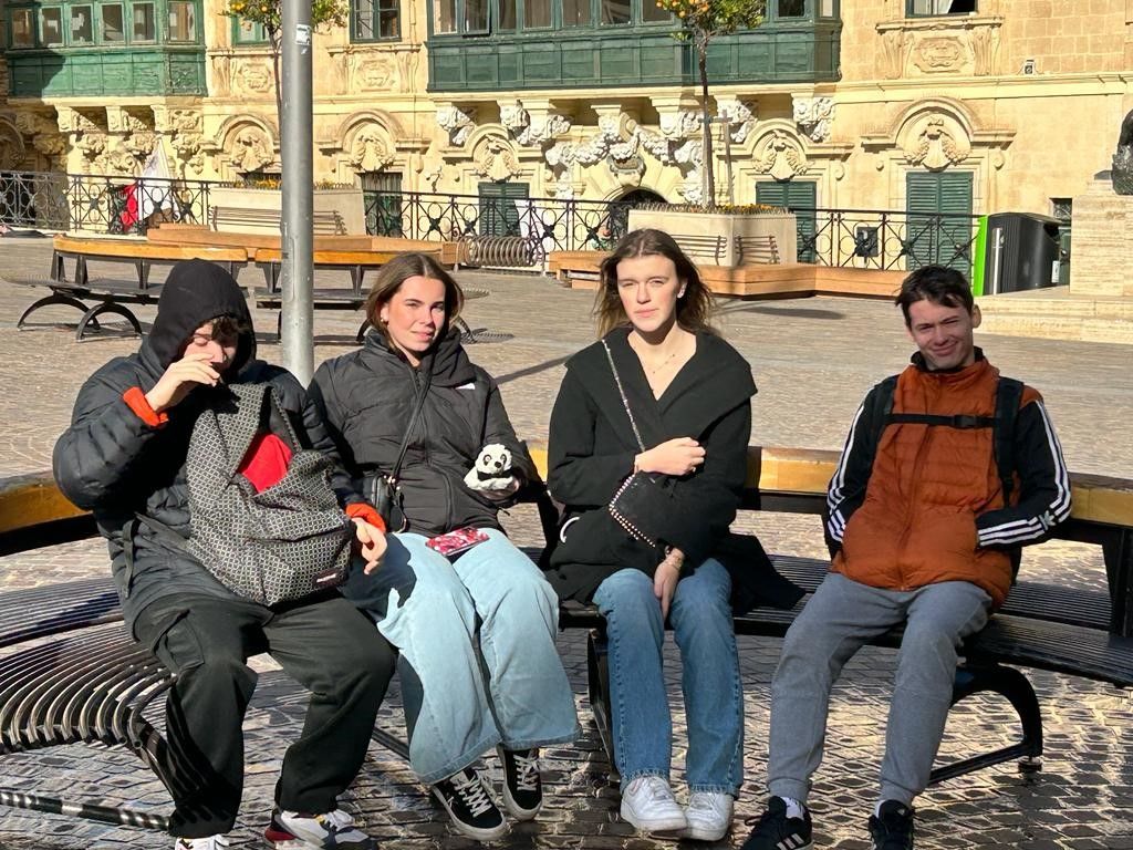 Quatre jeunes assis sur un banc