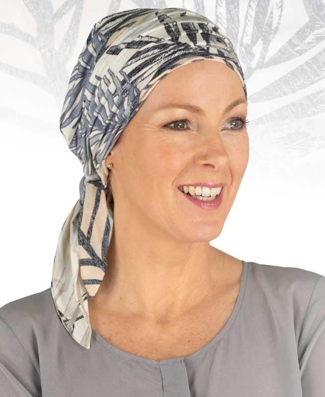 Eine Frau mit einem Schal um den Kopf lächelt