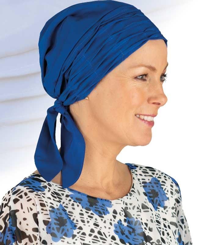 Eine Frau mit blauem Kopftuch lächelt