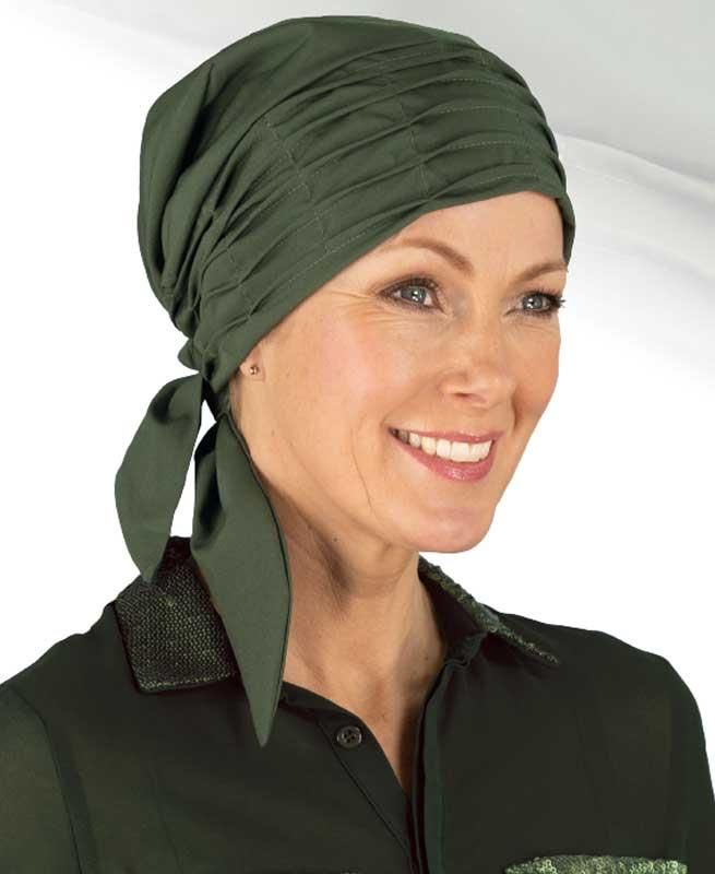 Eine Frau mit grünem Kopftuch lächelt