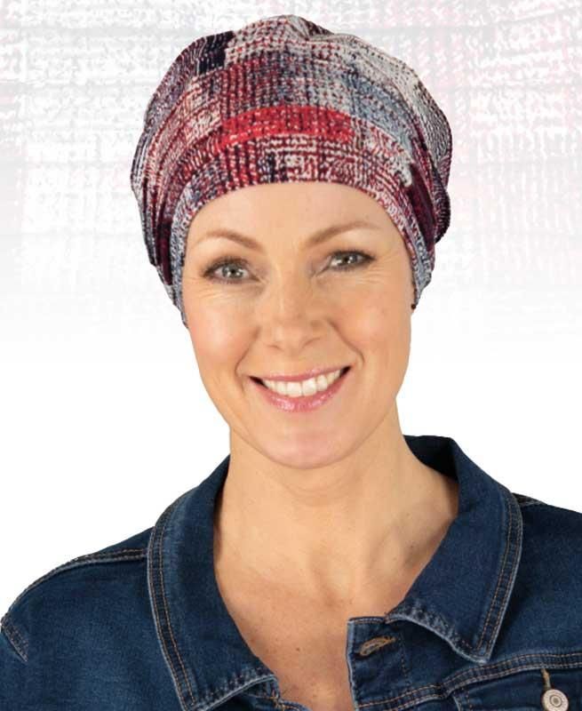 Eine Frau mit Turban und Jeansjacke lächelt in die Kamera