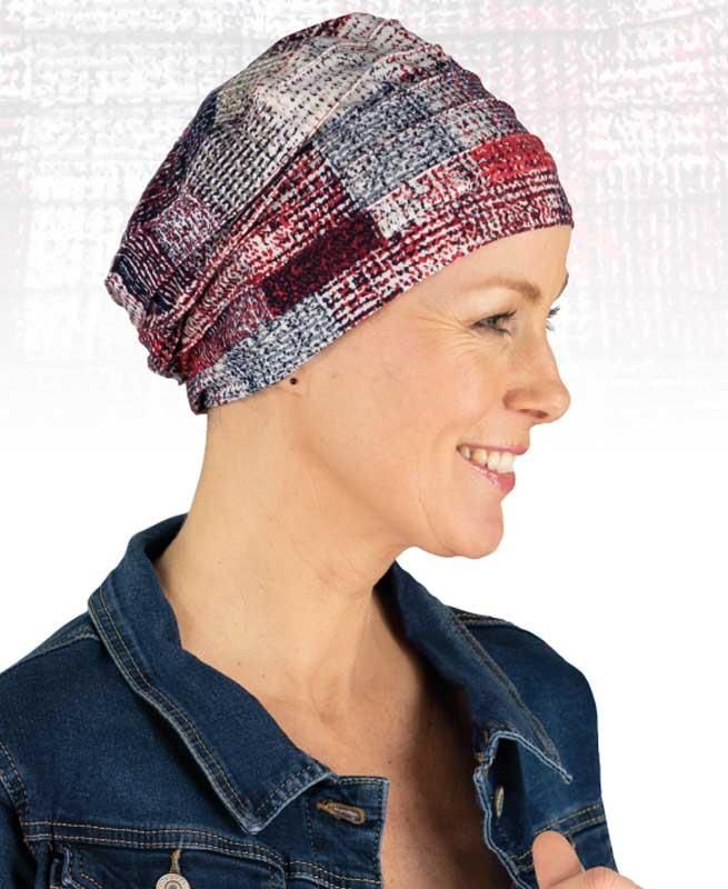 Eine Frau mit Hut und Jeansjacke lächelt