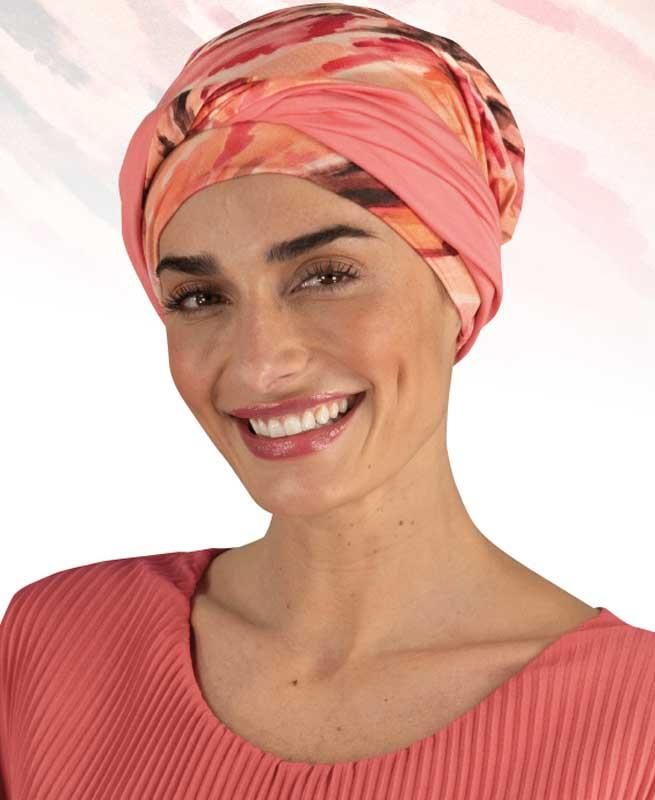 Eine Frau mit einem rosa Turban lächelt in die Kamera
