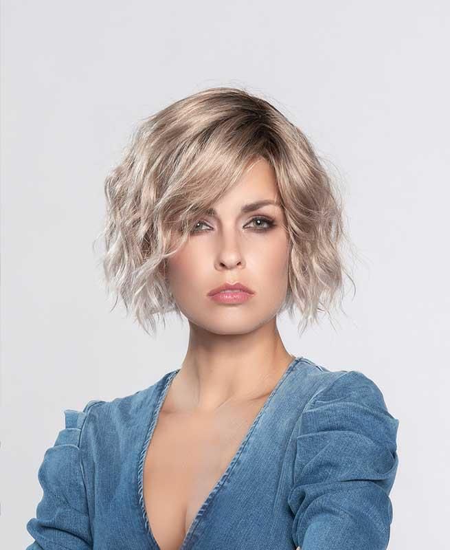 Die Frau trägt eine Perücke und ein blaues Kleid.