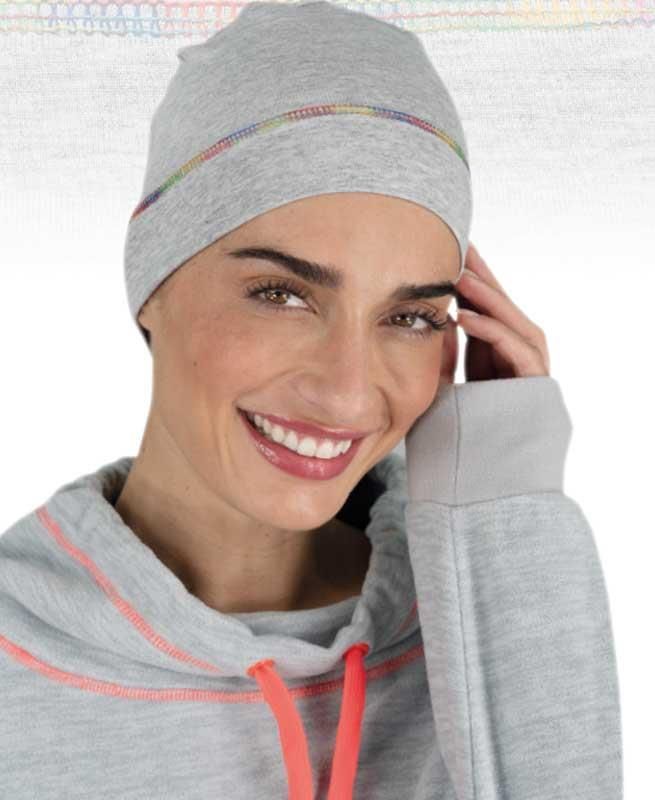 Eine Frau mit grauer Mütze und grauem Sweatshirt lächelt