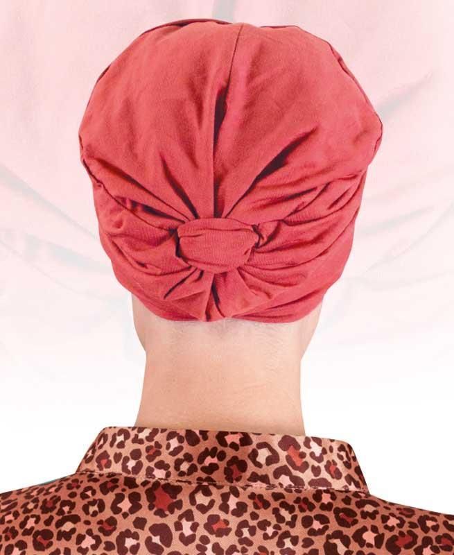 Eine Frau mit rotem Turban und Hemd mit Leopardenmuster