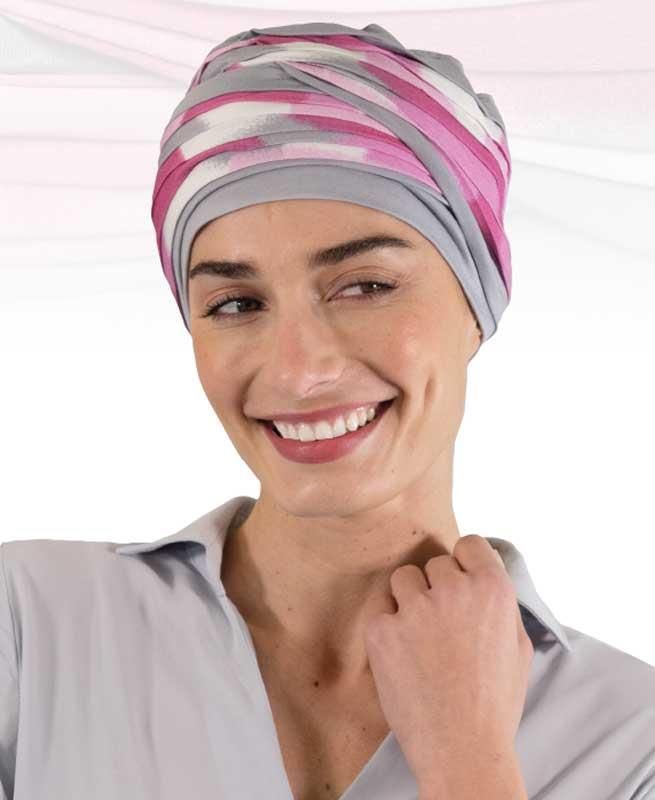 Eine Frau mit gestreiftem Turban lächelt in die Kamera