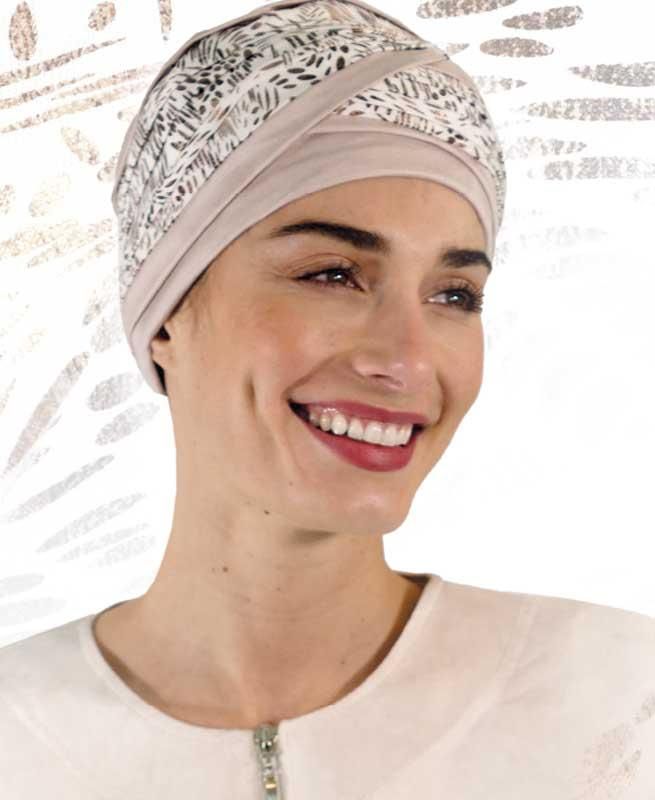 Eine Frau mit Turban lächelt und trägt ein weißes Hemd