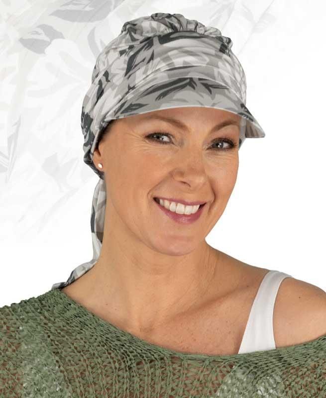 Eine Frau mit Hut und Schal lächelt in die Kamera