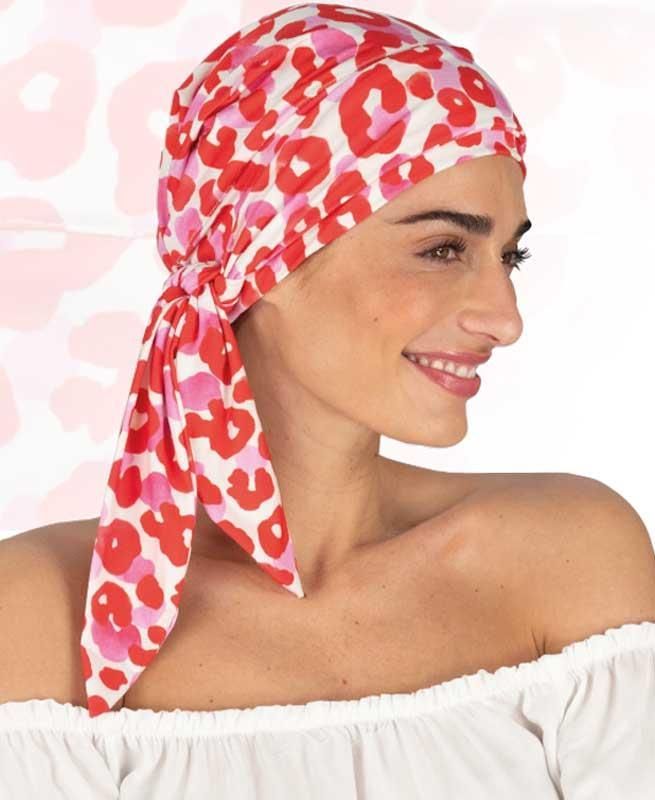 Eine Frau, die ein rot-rosa Kopftuch mit Leopardenmuster trägt