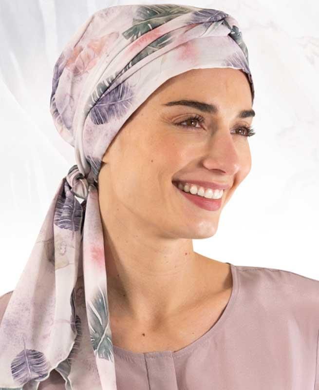 Eine Frau trägt ein Kopftuch und lächelt.