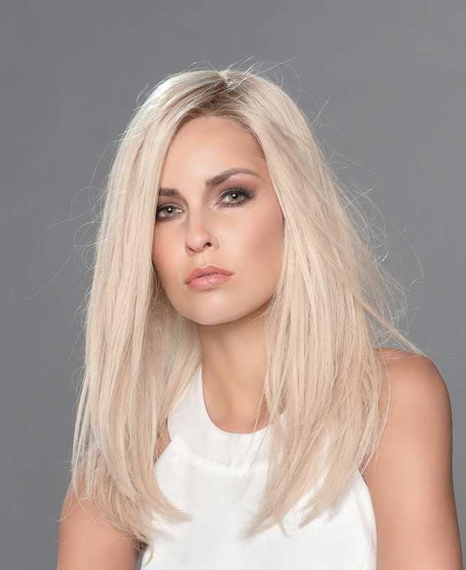 Eine Frau mit langen blonden Haaren trägt ein weißes Tanktop.