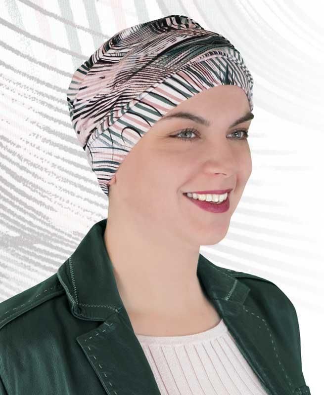 Eine Frau mit Turban und grüner Jacke lächelt