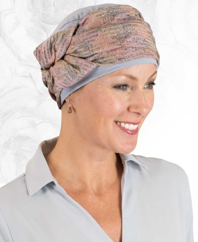 Eine Frau mit Turban und Ohrringen lächelt