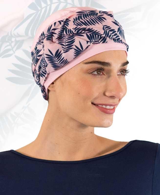 Eine Frau, die einen rosa Hut mit blauen Blättern darauf trägt