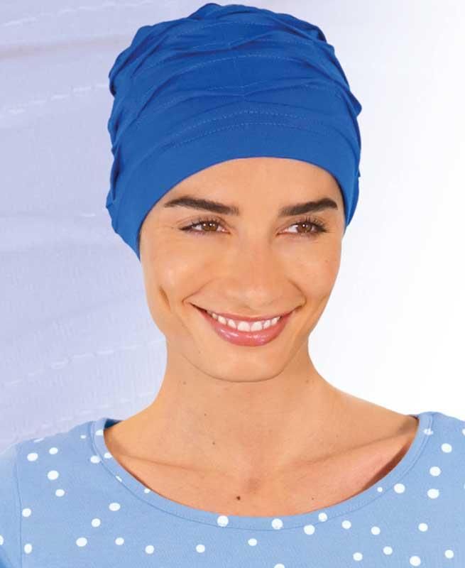 Eine Frau mit blauem Turban lächelt in die Kamera