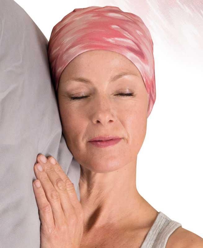 Eine Frau mit einem rosa Stirnband schläft mit geschlossenen Augen