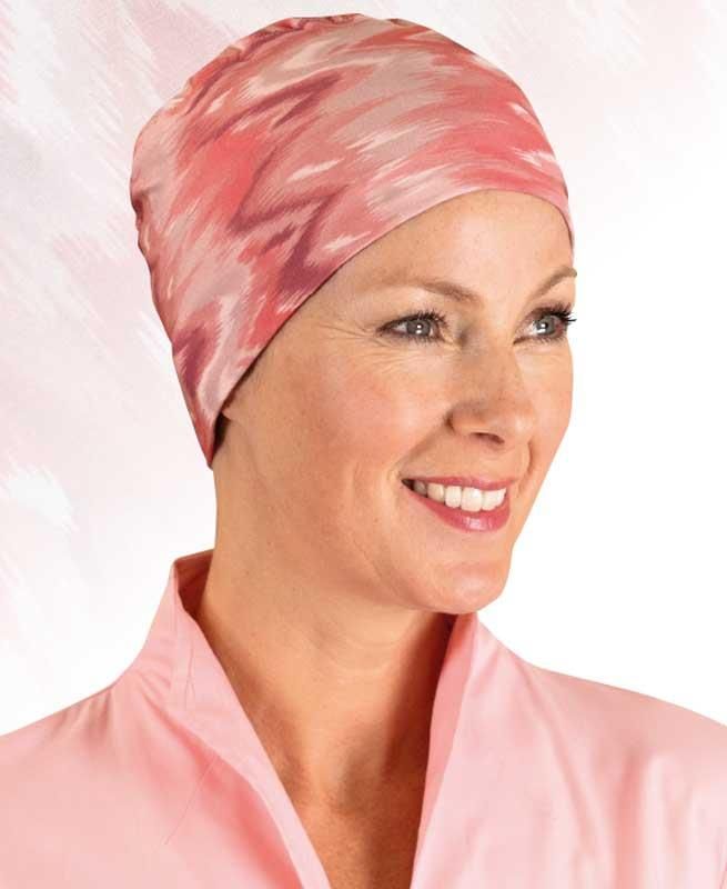 Eine Frau mit rosa Hut und rosa Robe lächelt