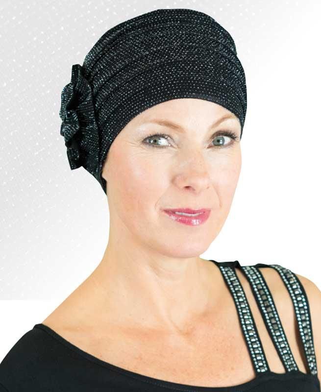 Eine Frau trägt einen schwarzen Hut mit einer Blume darauf