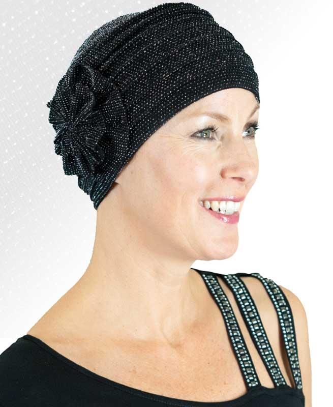 Eine Frau trägt einen schwarzen Hut und lächelt