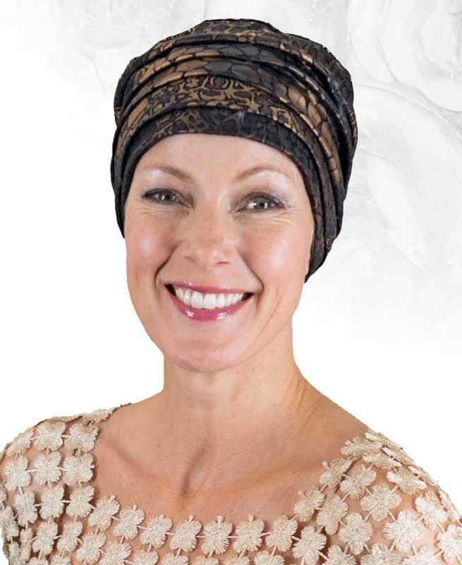 Eine Frau mit Turban und Spitzentop lächelt in die Kamera
