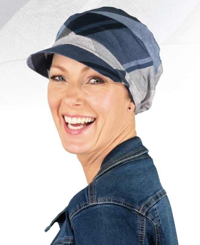 Eine Frau mit Hut und Jeansjacke lächelt