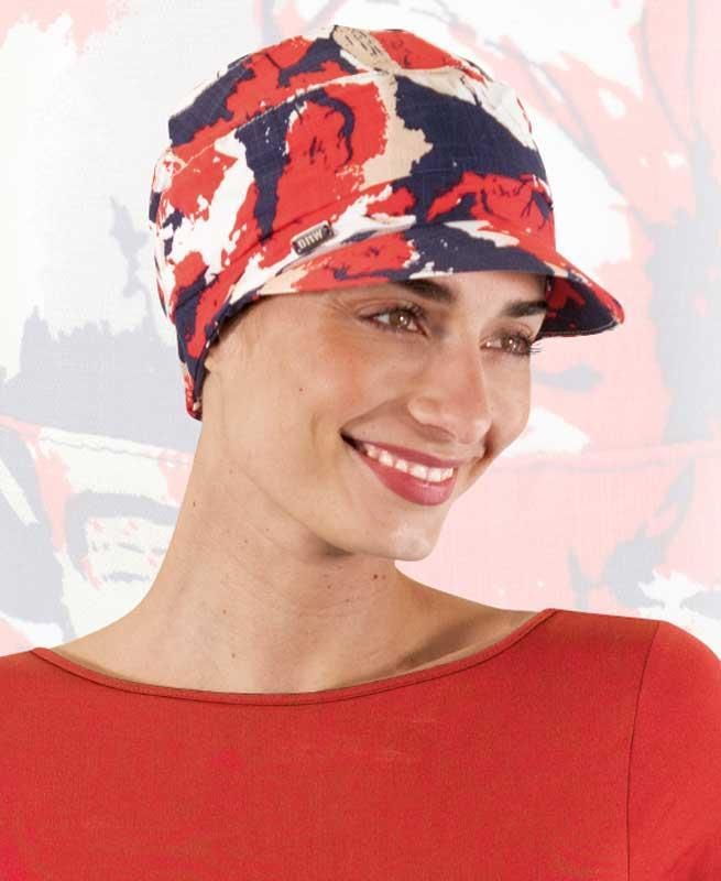 Eine Frau mit einem rot-blauen Hut lächelt