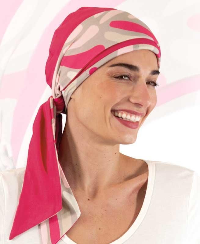 Eine Frau mit einem rosa Kopftuch lächelt