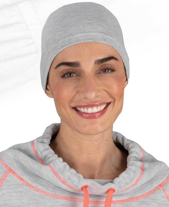 Eine Frau mit grauer Beanie und grauem Sweatshirt lächelt