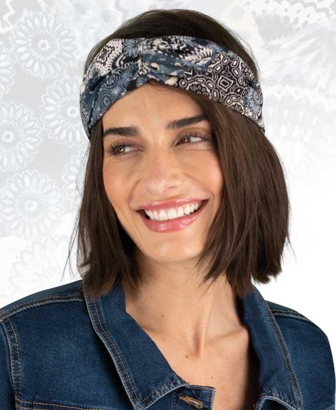 Eine Frau mit Stirnband und Jeansjacke lächelt.