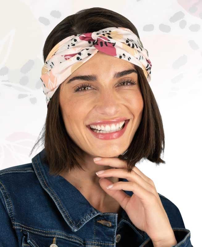 Eine Frau mit Stirnband und Jeansjacke lächelt.