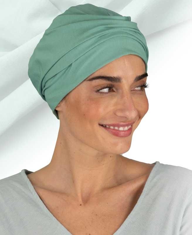 Eine Frau trägt einen grünen Turban und lächelt