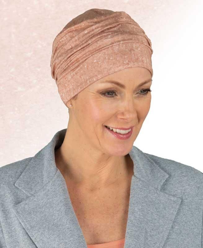 Eine Frau mit Turban und Jacke lächelt