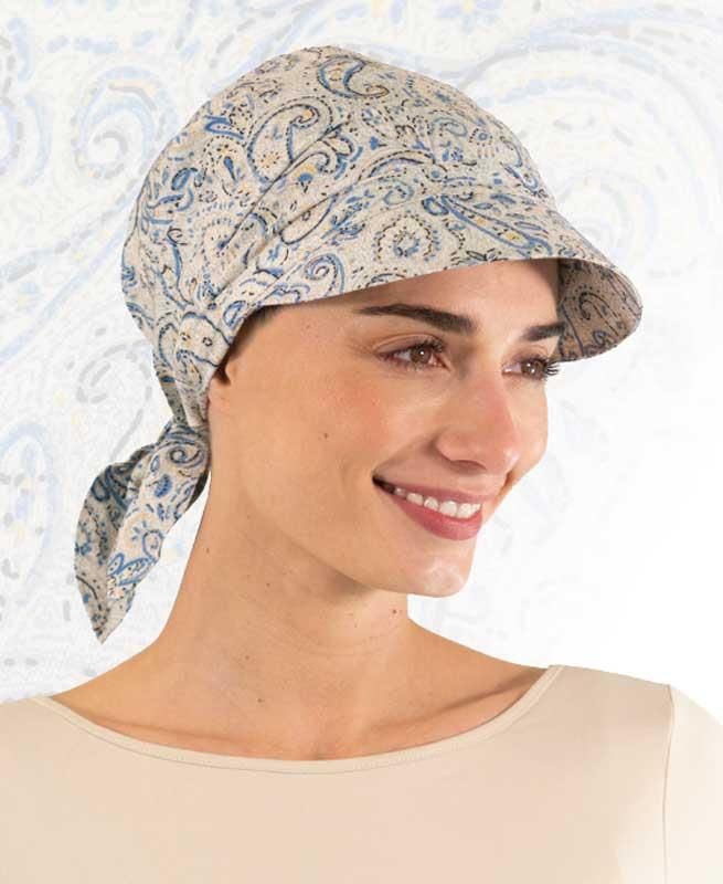 Eine Frau mit Kopftuch und Hut lächelt