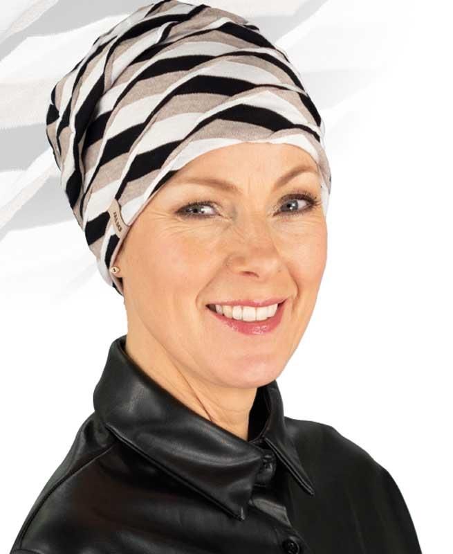 Eine Frau mit einem schwarz-weiß gestreiften Hut lächelt