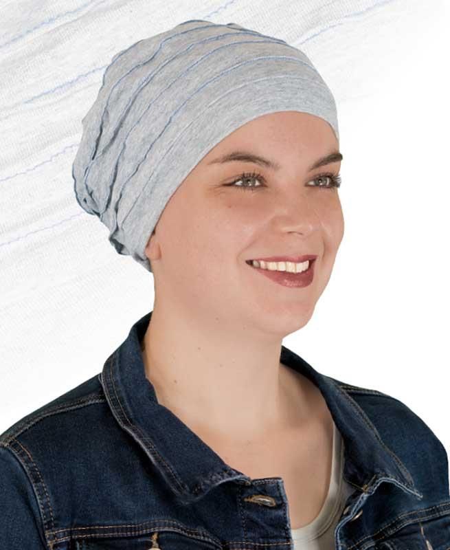 Eine Frau mit Hut und Jeansjacke lächelt