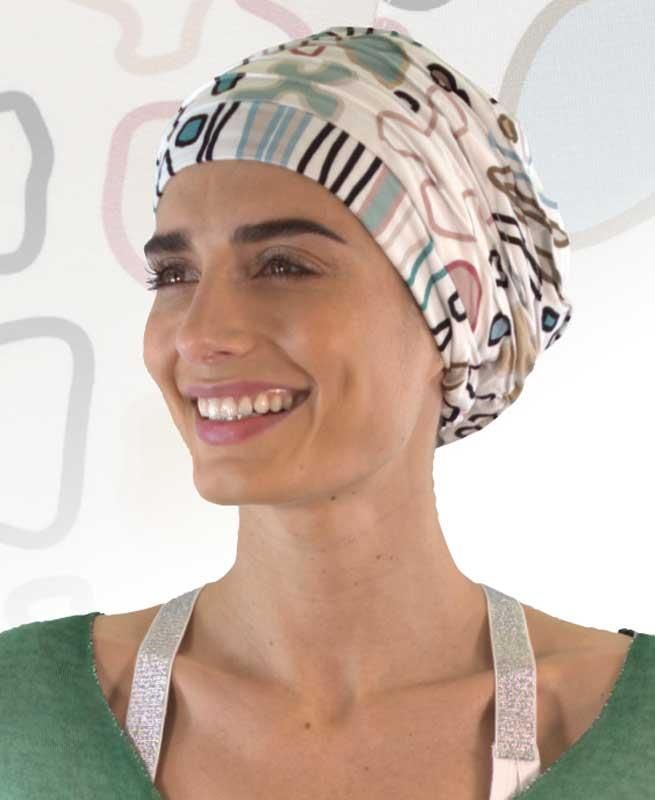 Eine Frau mit OP-Haube lächelt und trägt ein grünes Hemd