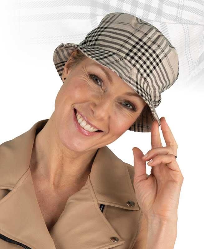 Eine Frau mit kariertem Hut lächelt in die Kamera