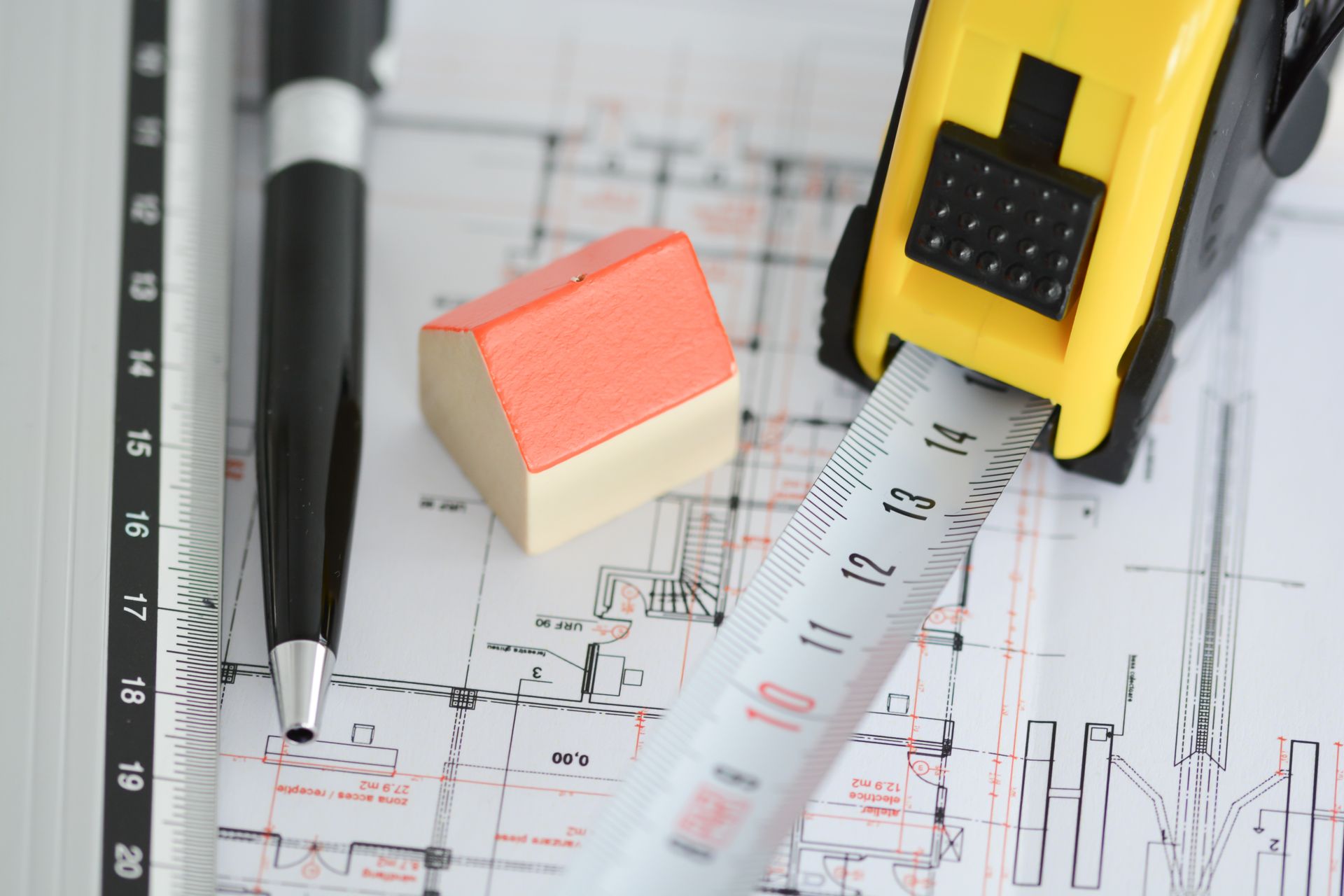Plan de construction, mètre, stylo et maison miniature