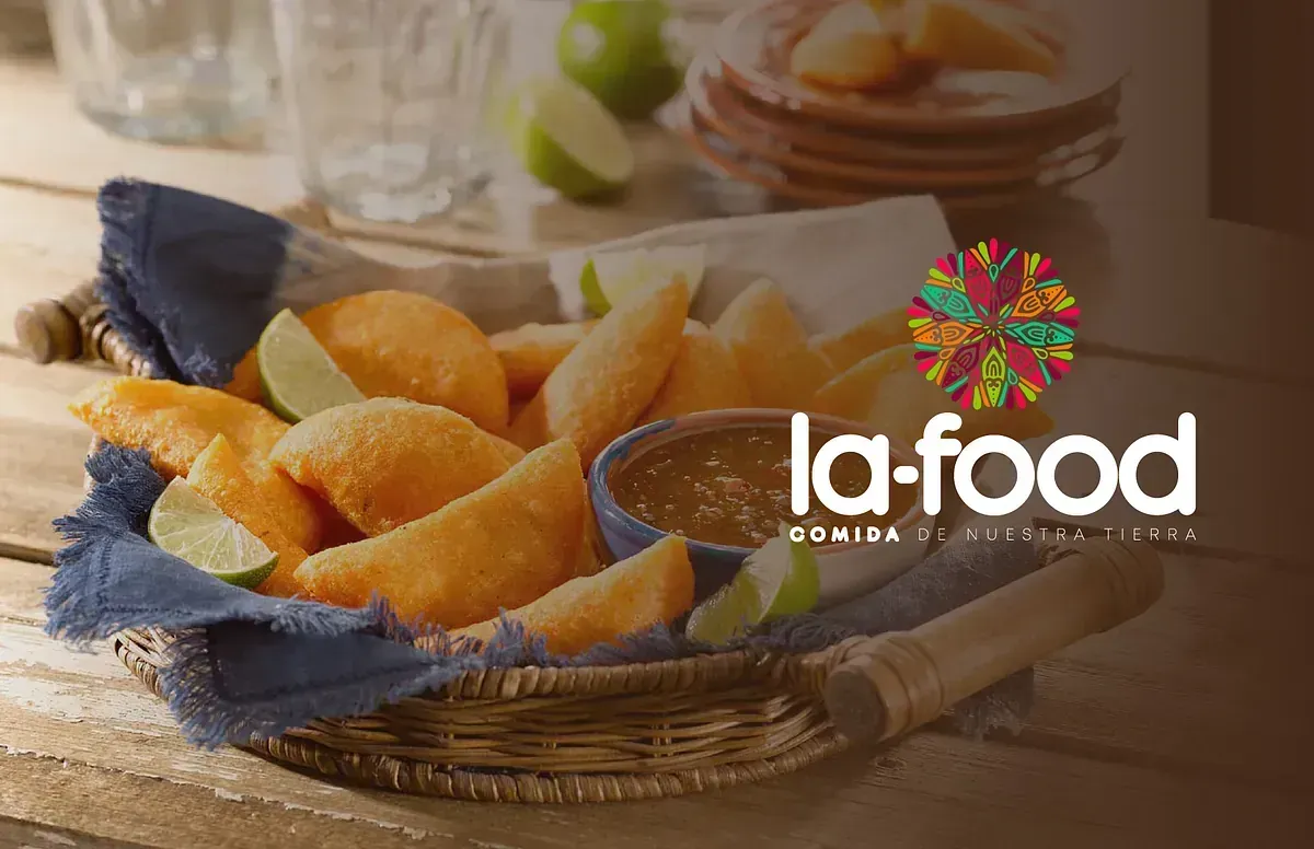 Una canasta de empanadas fritas doradas con gajos de limón, salsa y el logo de 