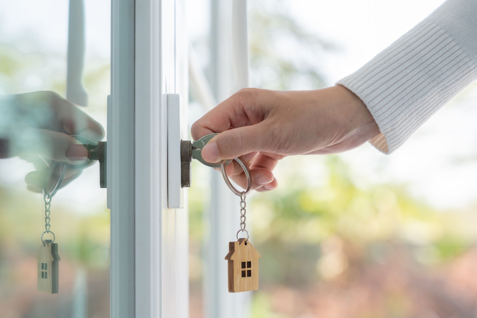 Main qui insère une clef dans une serrure de porte