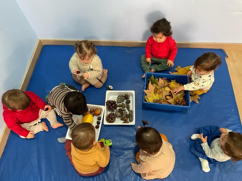 Un grupo de niños están sentados en mesas en un aula.