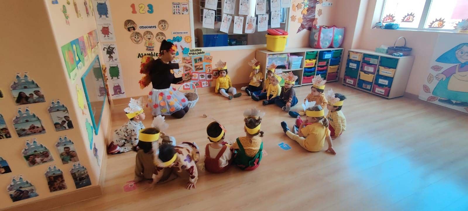 Un grupo de niños está sentado en el suelo en un aula.