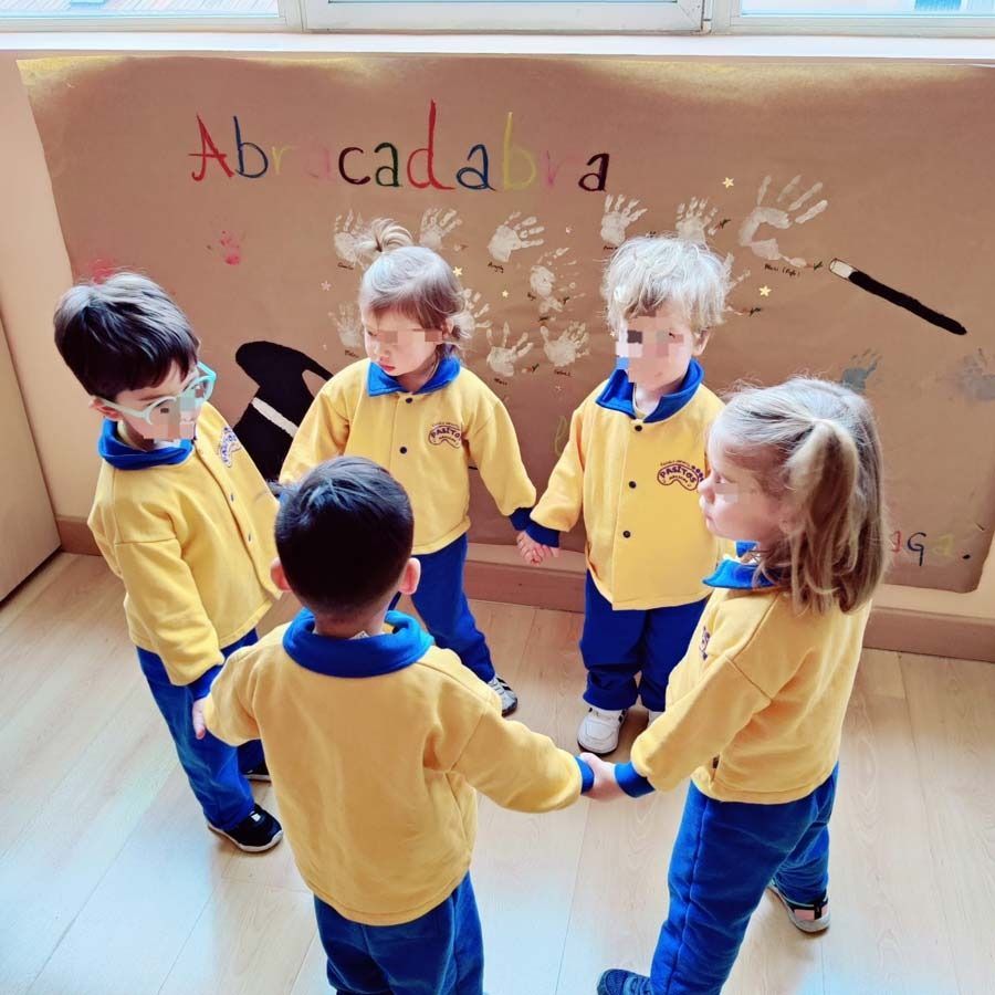 Un grupo de niños está parado frente a una pared que dice ab cada a