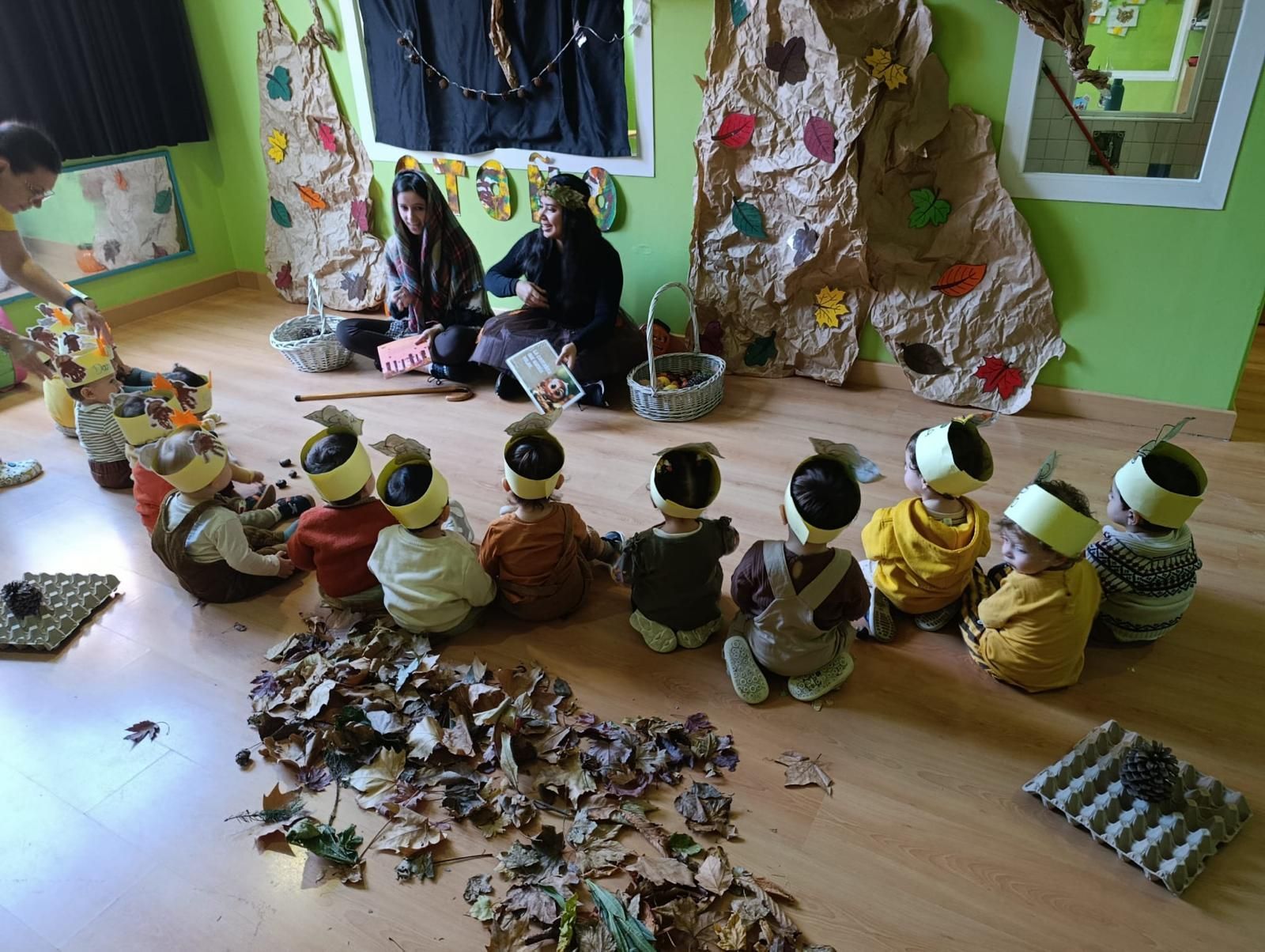Un grupo de niños está sentado en el suelo frente a una pared con el número 123.